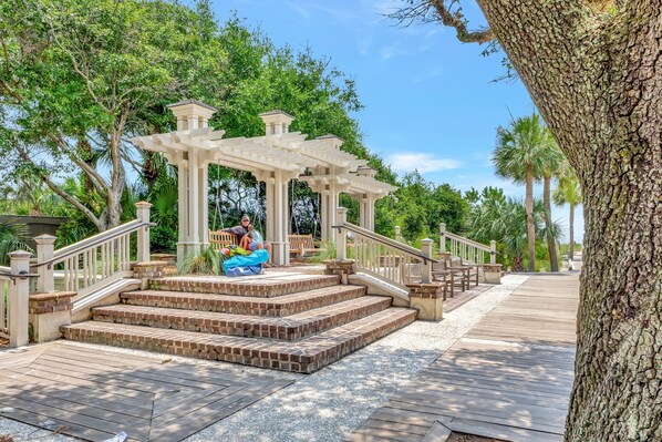 Step into a serene oasis surrounded by lush greenery and a picturesque pergola.