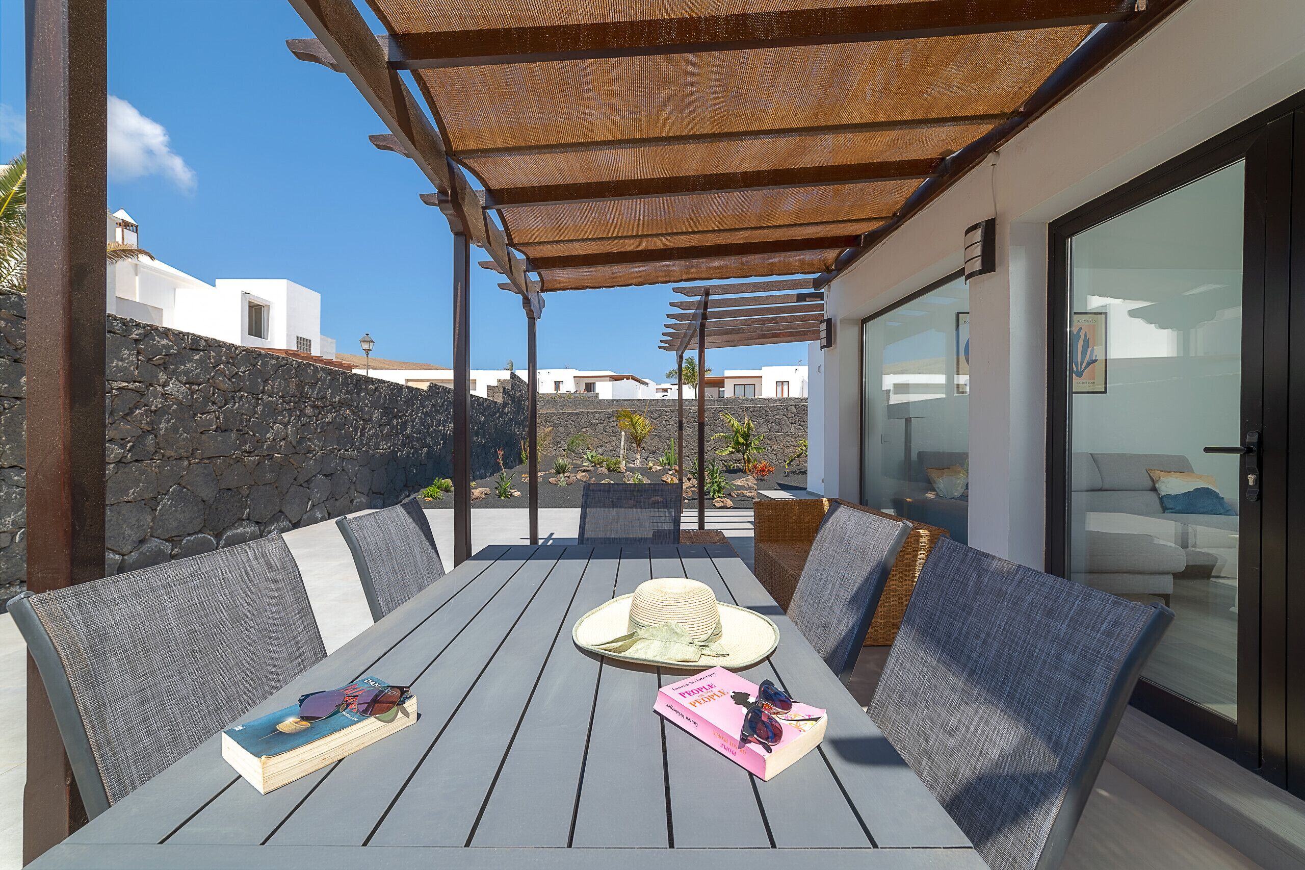 An outdoor seating area with a table, chairs, and a pergola.
