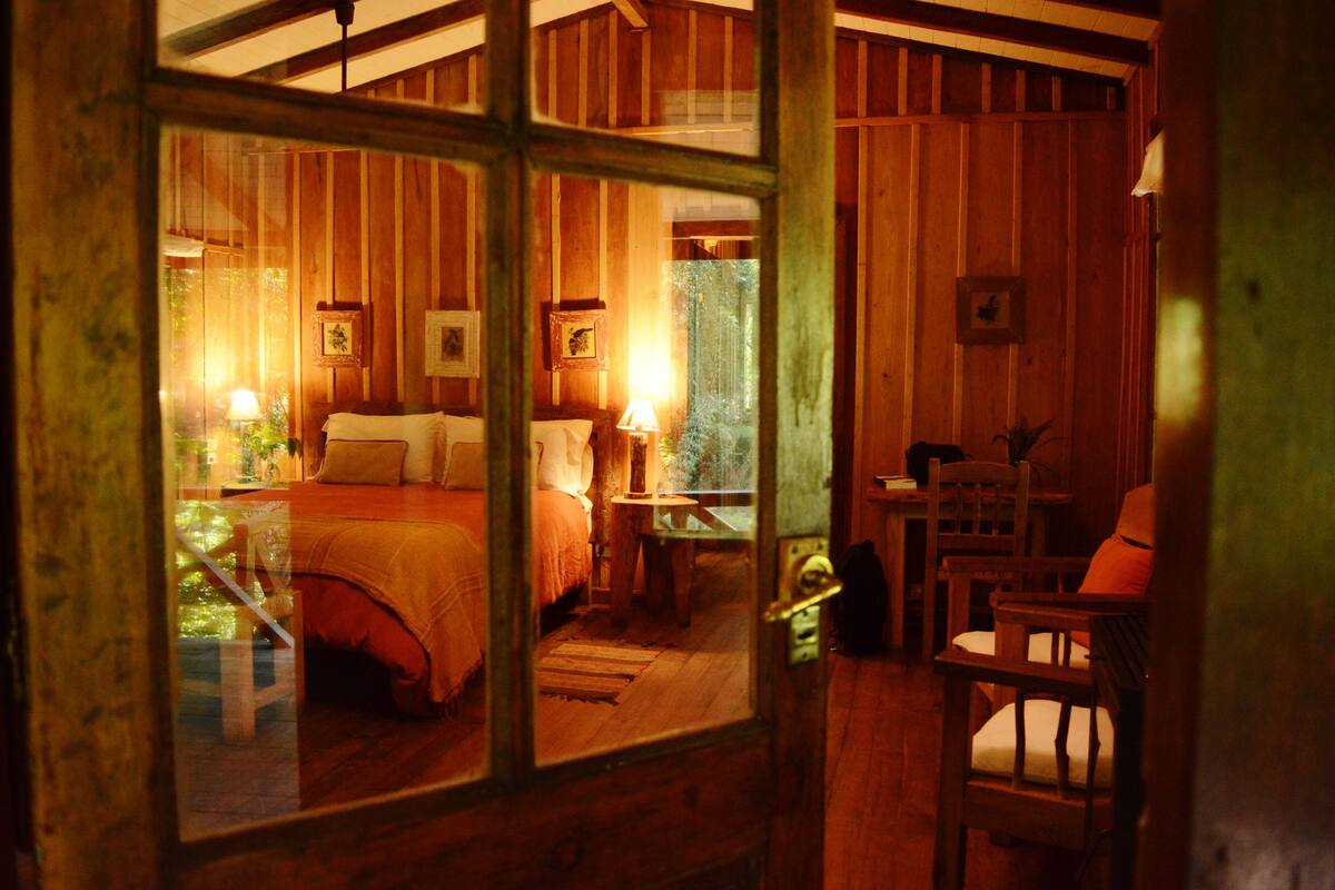 Une cabane en bois accueillante, avec un lit, une table et des chaises.