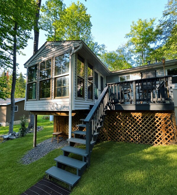 A house with a deck, a staircase, and a small outdoor seating area. - Pocono Lake House Walk To Beach Kayaks A/C (Pocono Lake)