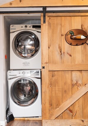 A laundry room with two front-loading washing machines and a wooden door with a metal handle. - Pocono Lake House Walk To Beach Kayaks A/C (Pocono Lake)