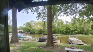 Un espace de pique-nique au bord du lac, équipé de bancs, d’une table de pique-nique couverte et de bateaux amarrés au quai.