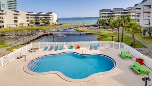 A swimming pool with lounge chairs and a view of the ocean. - Bayfront Pensacola Beach Condo w/ Pool & Elevator (Pensacola Beach)