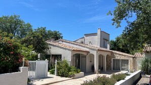 Een huis in mediterrane stijl met een pannendak, een overdekt terras en een tuin met lavendel.