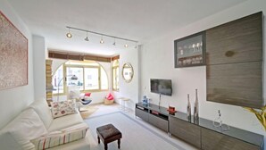 A modern living room with a sofa, coffee table, and a TV mounted on the wall. - Mare Nostrum by Interhome (Calpe/Calp)