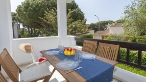 A dining area with a table set for four, surrounded by wooden chairs.