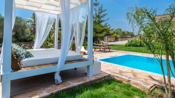 A bed with a canopy, a pool, and a picnic table in a garden setting. - Sa Caseta by Interhome (Ses Salines)