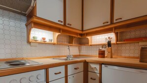 Une cuisine avec des armoires blanches, des comptoirs en bois et un dosseret en carreaux hexagonaux.