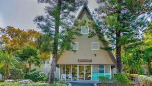 A Key Largo building with a triangular roof, surrounded by trees and a small garden. - Key Largo Relaxing Getaway (Key Largo)