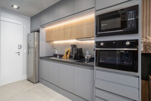 A modern kitchen with stainless steel appliances, wooden cabinets, and a built-in oven.