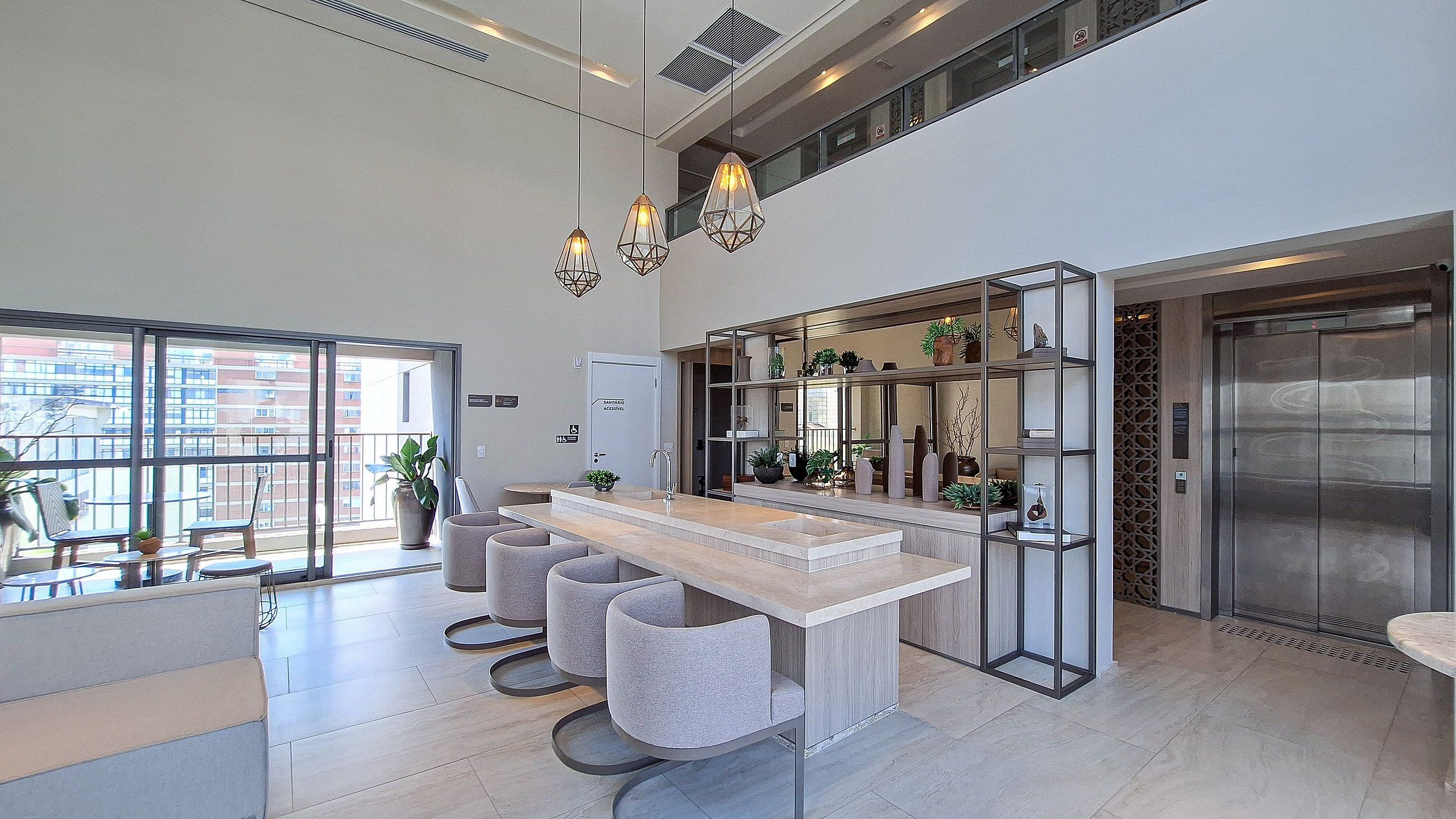 Una cocina moderna con una isla central, iluminación colgante y vistas a la ciudad a través de amplios ventanales.