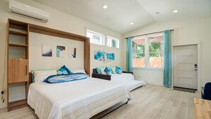 A bedroom with two beds, a wooden wardrobe, and artwork on the wall. - Urban-chic Studio Guesthouse in a quiet neighborhood - near Intel and Nike (Hillsboro)