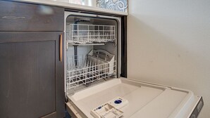 An open dishwasher with two racks, a control panel, and a white interior. - Urban-chic Studio Guesthouse in a quiet neighborhood - near Intel and Nike (Hillsboro)