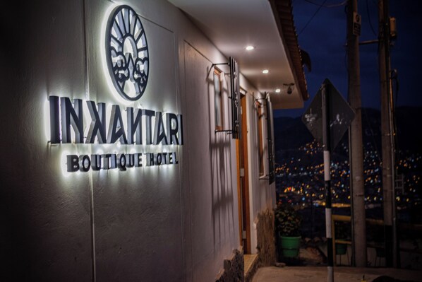 A sign for Innamar Boutique Hotel with a cityscape view in the background. - Inkantari Boutique Hotel (Cusco)