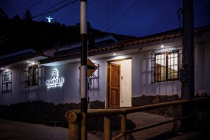 A boutique hotel with a sign reading "INNAMTARI BOUTIQUE HOTEL," a wooden door, and barred windows. - Inkantari Boutique Hotel (Cusco)