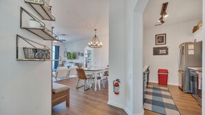A modern kitchen with a built-in fridge, a red trash bin, and a checkered rug.