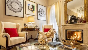 Una sala de estar acogedora con dos sillones, una chimenea y una mesa de centro con libros.