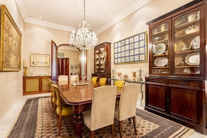 A formal dining room with a wooden table, chairs, a chandelier, and a china cabinet. - 16th-century villa for 14, near Valencia | Villa Paula (Manises)