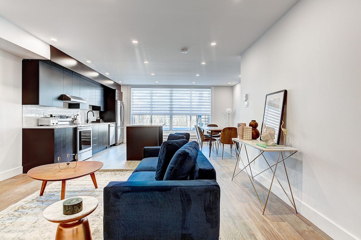 A modern apartment with a kitchen, dining area, and living room.