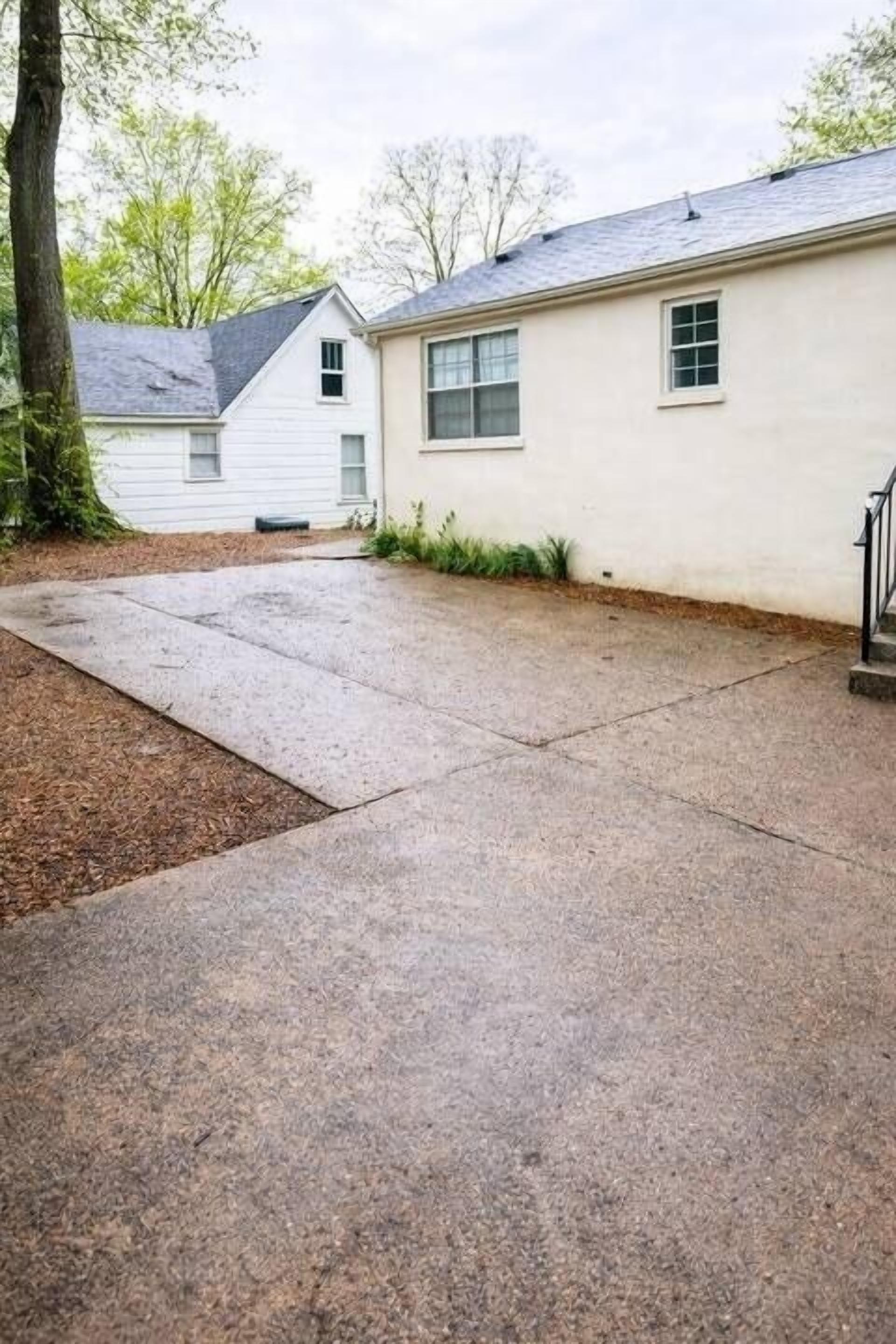 A residential driveway leading to a house with a covered garage.