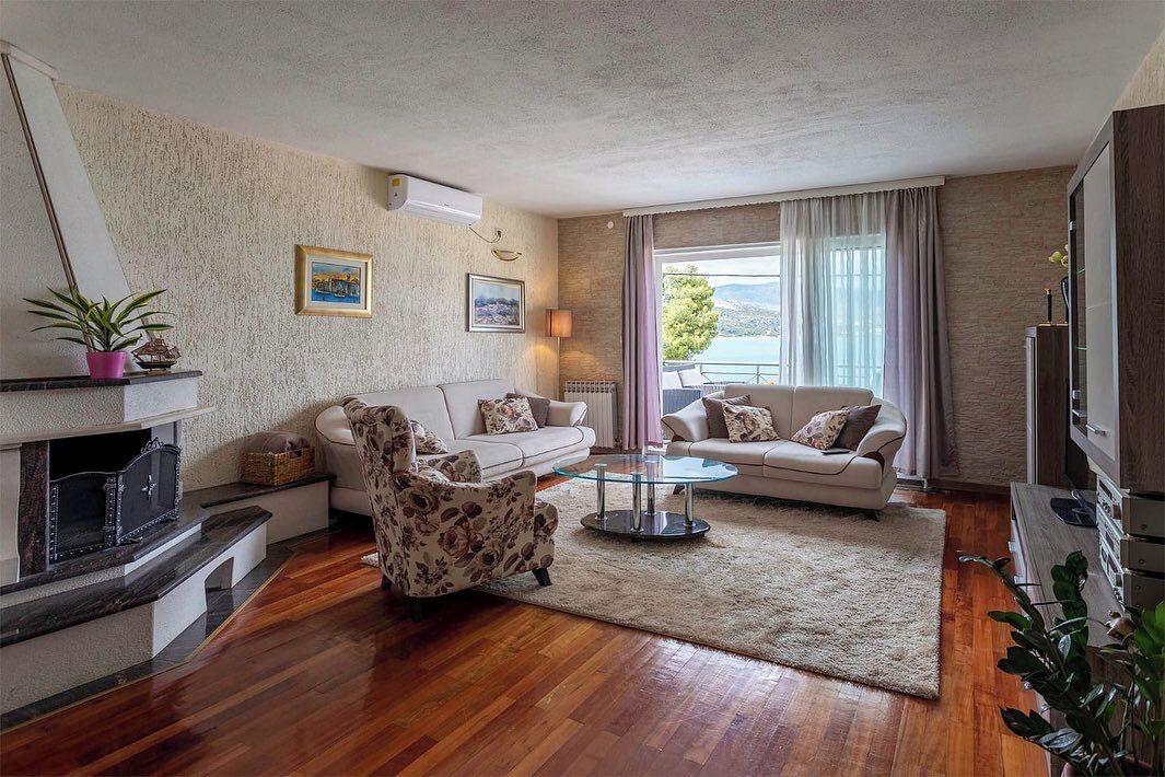 A living room with a fireplace, two sofas, a coffee table, and a TV.