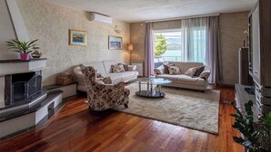 A living room with a fireplace, two sofas, a coffee table, and a TV.