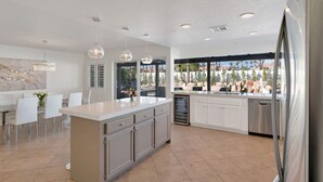 A modern kitchen with a central island, white cabinetry, and pendant lighting. - 10 Bd/walk 2 shuttle 4 Stagecoach/Ask-Deals/Games (La Quinta)