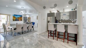 Een moderne keuken met een bar, marmeren vloer en moderne verlichting.