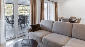 Un salon moderne comprenant un canapé, une petite table et un coin repas avec des chaises et une table.
