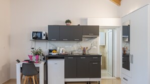 Eine moderne Küche mit integriertem Mikrowellenherd, einem kleinen Kühlschrank und einer Spüle.
