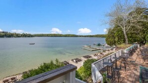 Un patio junto al lago con mobiliario exterior y un muelle.