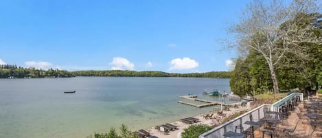 Un patio junto al lago con mobiliario exterior y un muelle.