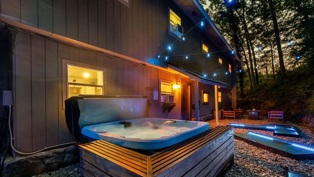 A wooden spa building with a hot tub, outdoor seating, and string lights. - Dog Friendly, 3 Bedrooms, Hot Tub, Peaceful & Private, Mini Golf, Coffee Bar! (Sevierville)