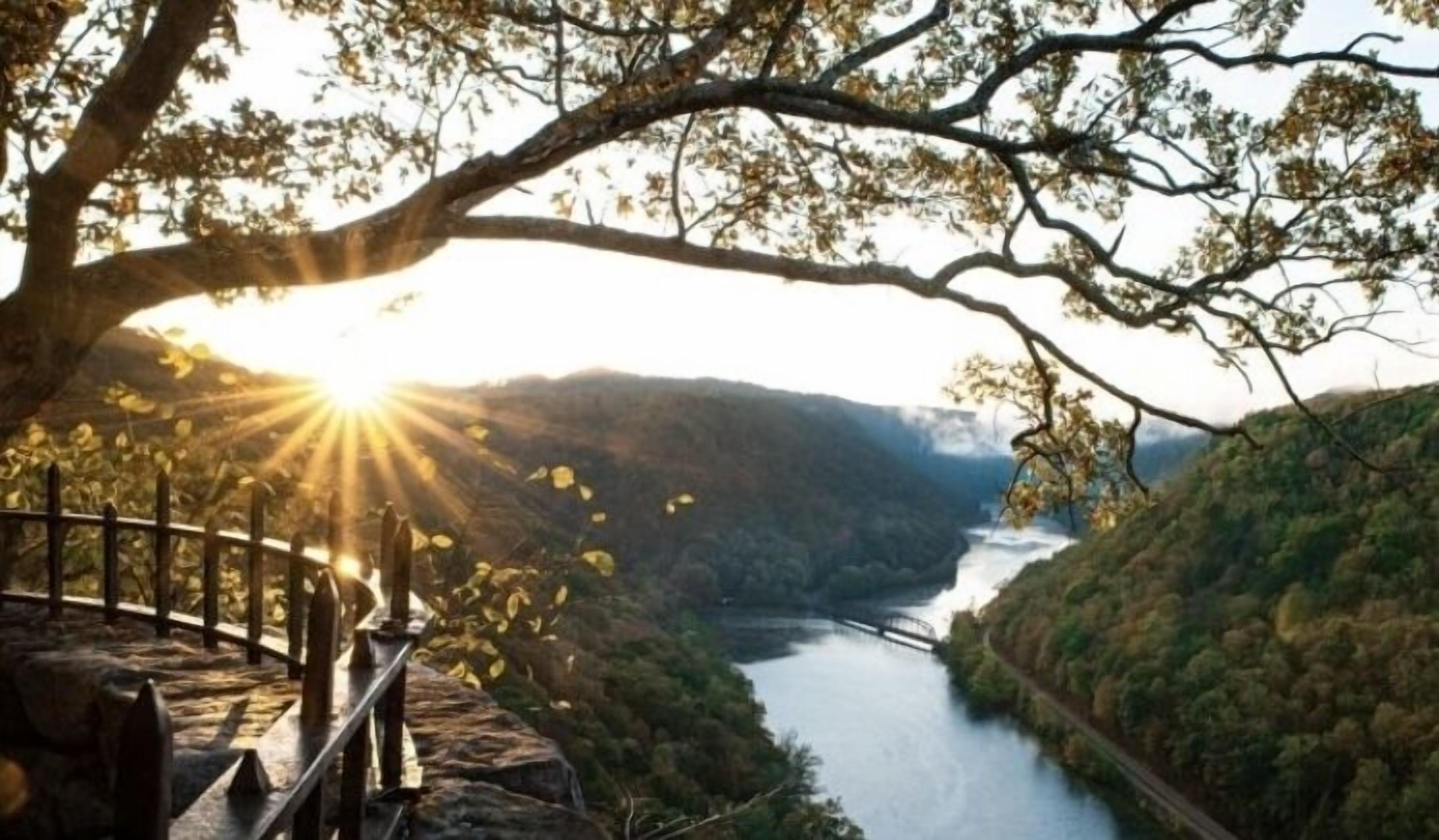 A scenic overlook with a river, a bridge, and a railing.