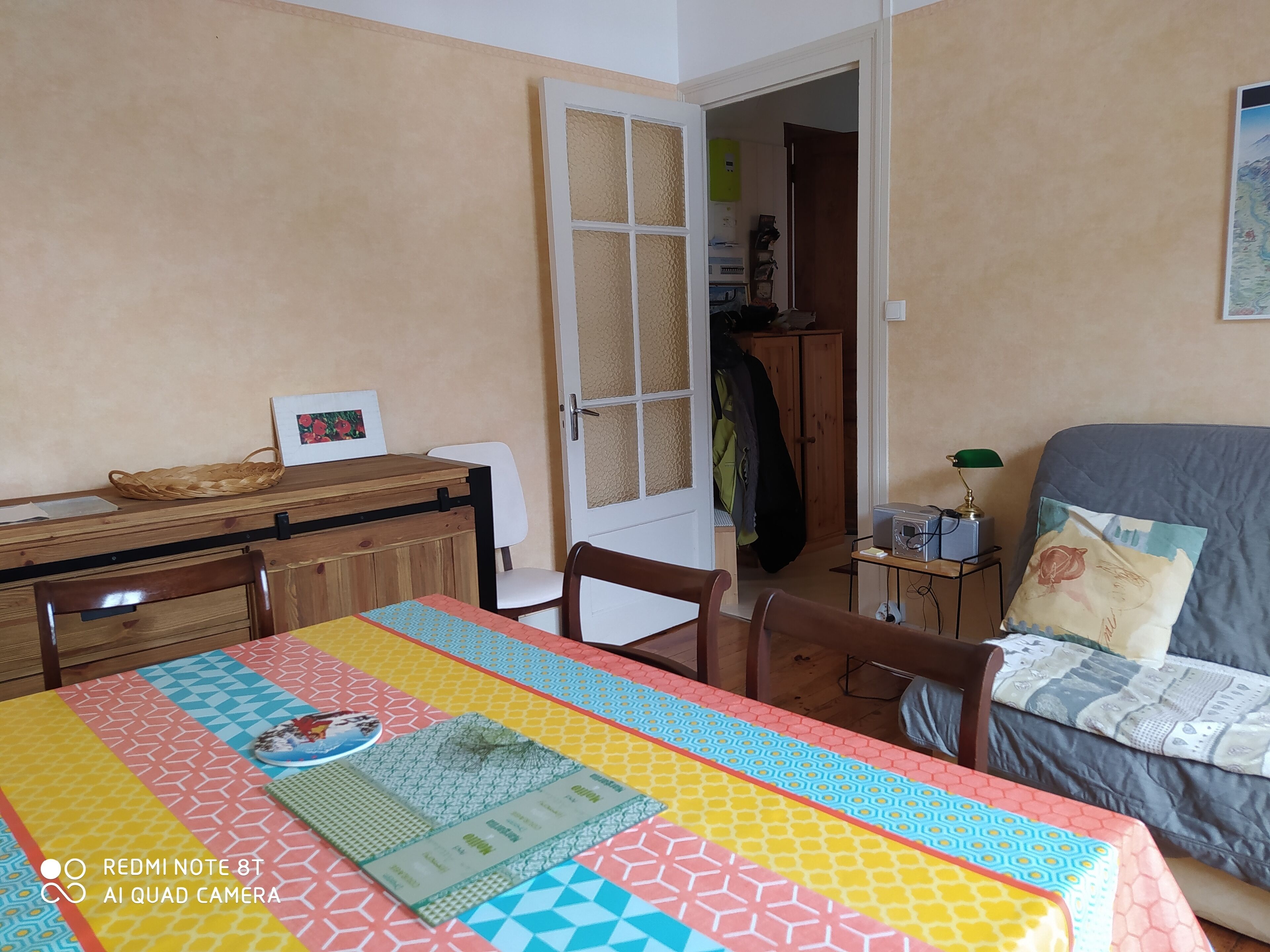 Une pièce comprenant une table à manger, des chaises, un lit et une armoire.