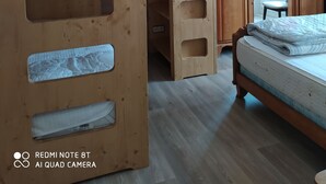 Ein Zimmer mit einem Etagenbett, einem Kleiderschrank und einem Schreibtisch.