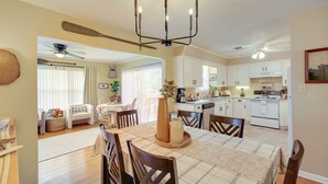 A dining area with a table set for four, a chandelier, and a view into the kitchen. - Lake Hamilton Home: 5 Mi to Hot Springs! (Hot Springs)