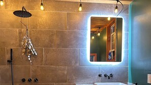Une salle de bain moderne avec une douche en bois, un grand miroir et un meuble-lavabo en bois.