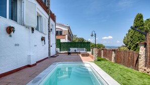 A swimming pool with a stone wall and a wooden deck. - VERDI: House with spectacular sea views and private pool in Pals (Pals)