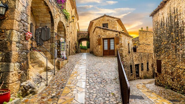 A narrow cobblestone street flanked by stone buildings with arched doorways and a small bridge overhead. - VERDI: House with spectacular sea views and private pool in Pals (Pals)