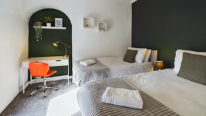 Ein modernes Schlafzimmer mit zwei Betten, einem Schreibtisch und einem Stuhl.