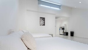 Moderni hotellihuone, jossa on suuri sänky, yöpöytä, pieni työpöytä ja peili.
