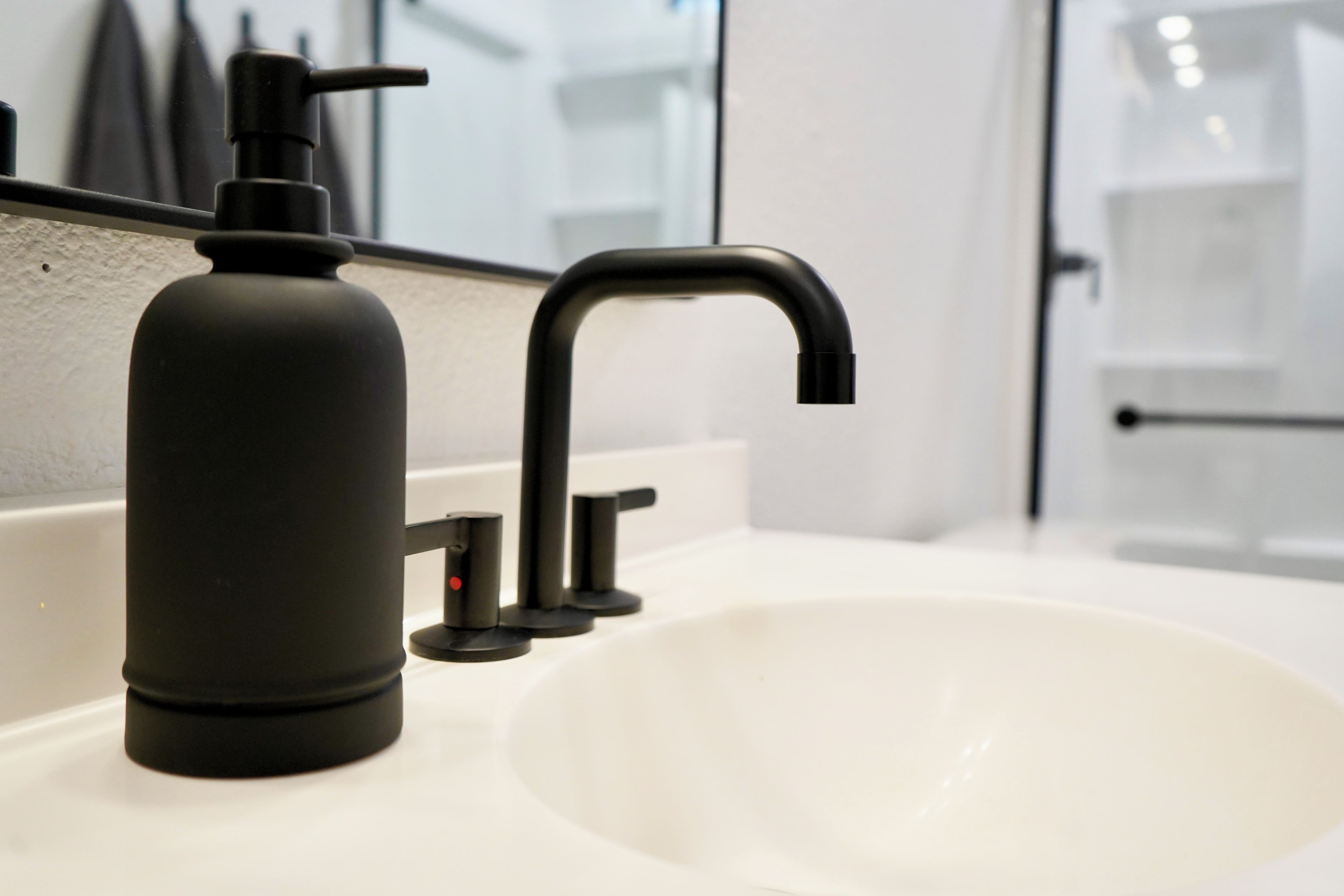 Un lavabo de salle de bain doté d’un robinet moderne et d’un distributeur de savon.