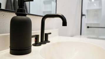 Un lavabo de salle de bain doté d’un robinet moderne et d’un distributeur de savon.