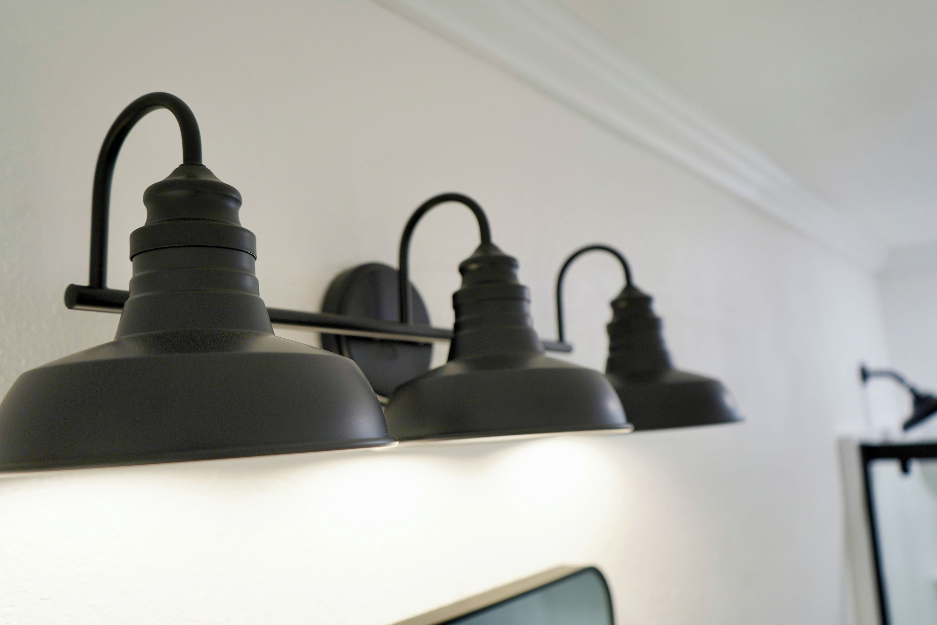 A row of wall-mounted light fixtures with a curved design.