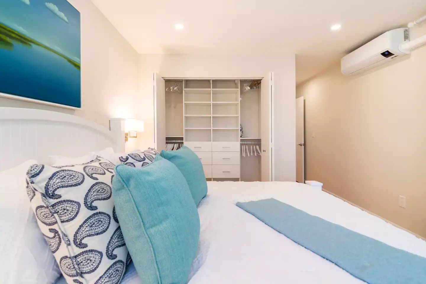Ein Schlafzimmer mit einem Bett, einem Kleiderschrank und einer Wand-Klimaanlage.