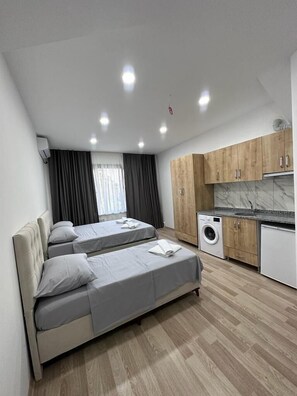 Habitación triple Deluxe | 1 habitación, caja de seguridad en la habitación y cortinas blackout