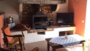 A cozy living room with a fireplace, a television, and comfortable seating. - Le Vernay - Pierreclos (PIERRECLOS)
