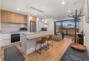 Enjoy cooking and dining in this spacious living area with a central kitchen island, oven, and dining table.