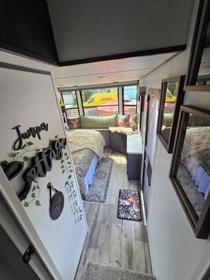 A compact living space with a bed, seating area, and a small table.